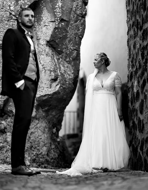 Mariage au Beausset : couple posant en noir et blanc dans une ruelle en pierre.
