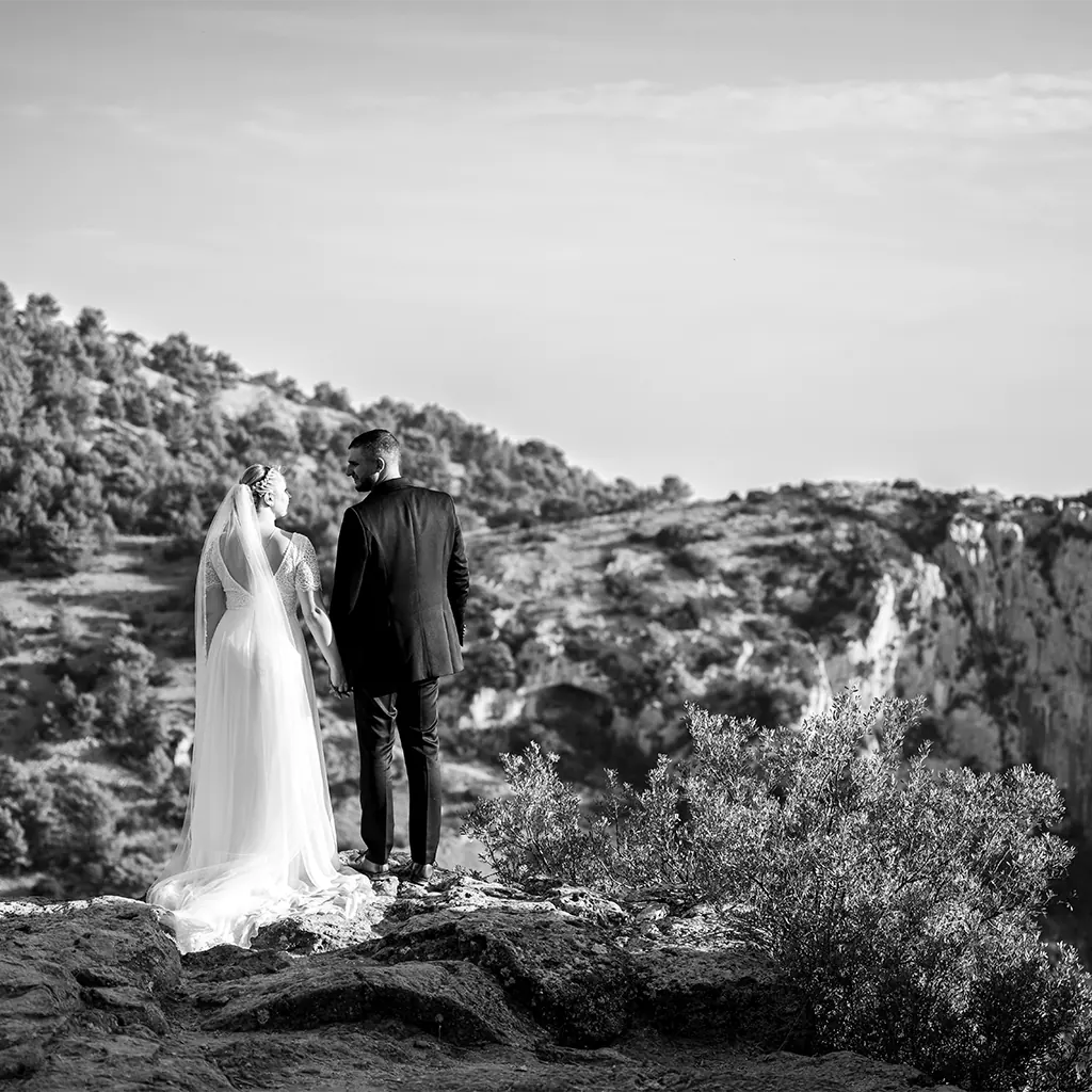 Mariage au Beausset : couple de mariés en noir et blanc, de dos, admirant le paysage depuis une falaise.