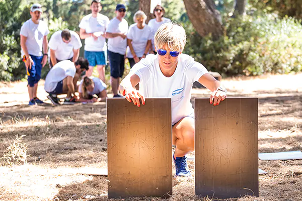 Photographie d'un séminaire d'entreprise : des collègues souriants lors d'une activité de cohésion en plein air.