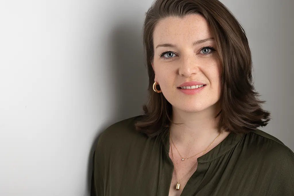 Portrait corporate d'une femme souriante sur fond gris, réalisé en studio par un photographe professionnel au Beausset, Var.