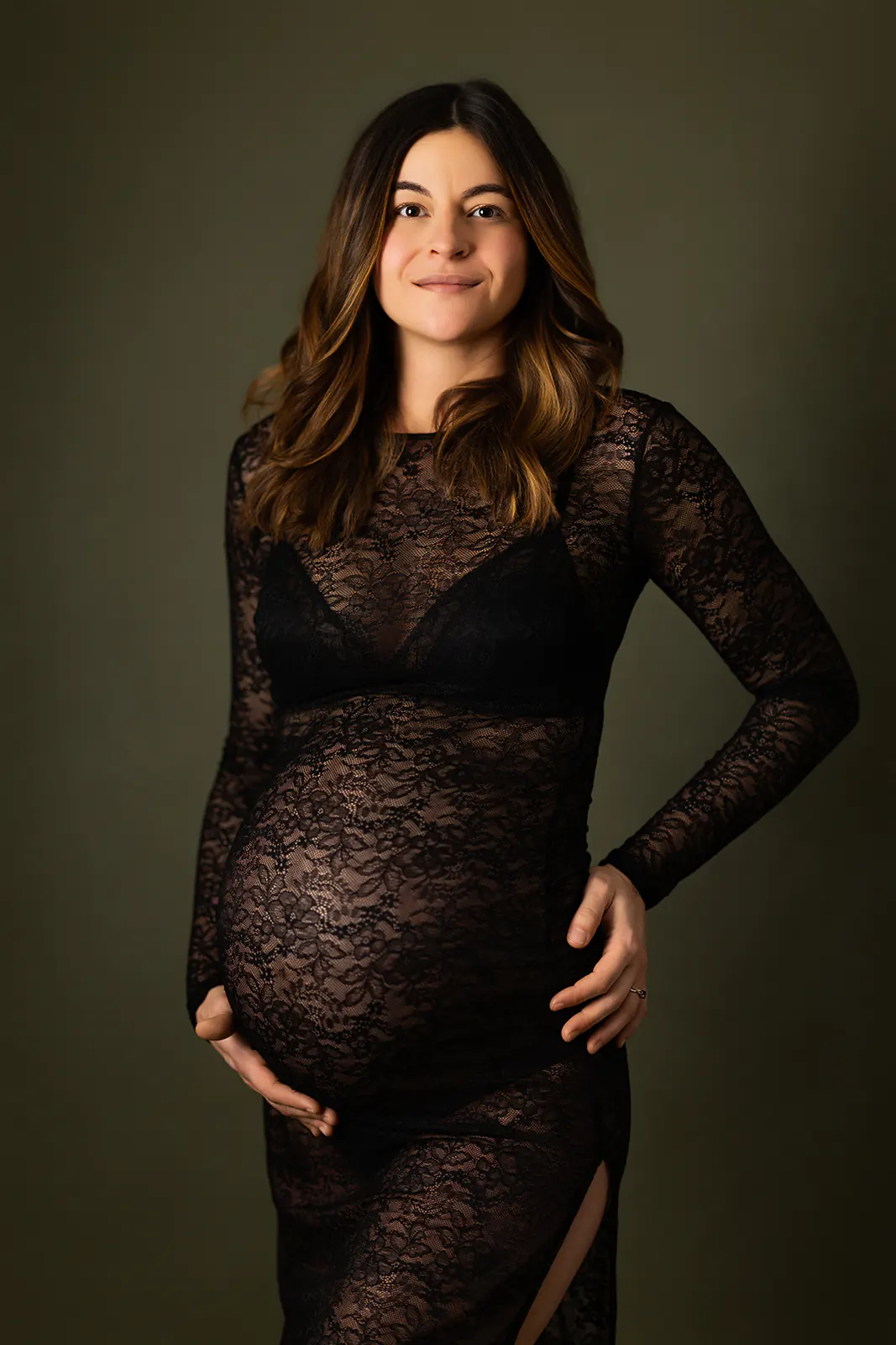 Séance photo grossesse à Ollioules : portrait élégant en studio d'une future maman portant une robe de maternité en dentelle noire.