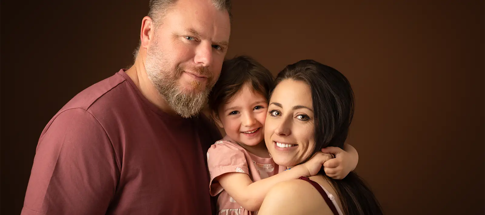 Portrait complice de parents avec leur fille lors d’une séance photo de famille à Ollioules