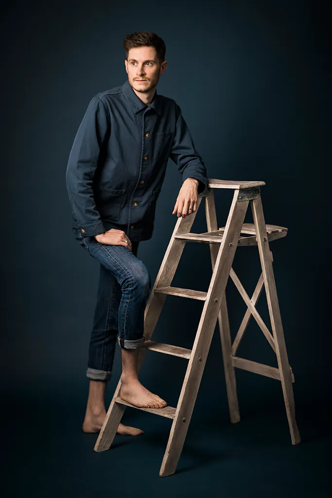 Portrait artistique en studio d’un homme posé sur une échelle – photographe à Sanary-sur-Mer